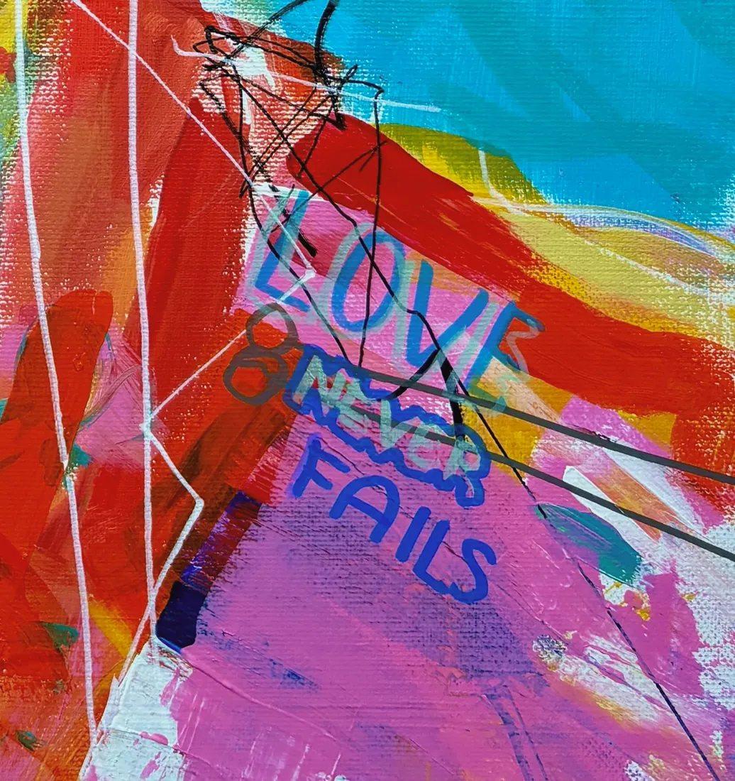 Detail of the painting Love Never Fails, with the words LOVE NEVER FAILS painted into the canvas